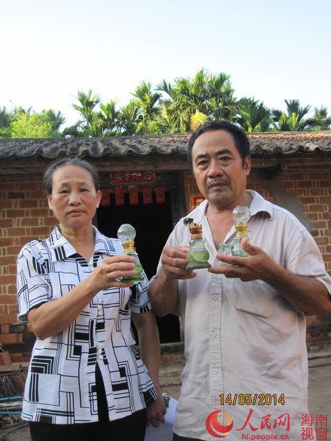 陈运弟和妻子展示孩子用过的煤油灯
