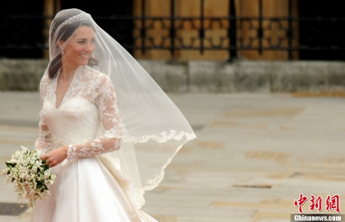 凯特身披嫁纱，头顶白纱，手捧新娘花束，婚纱获得时尚界一致好评
