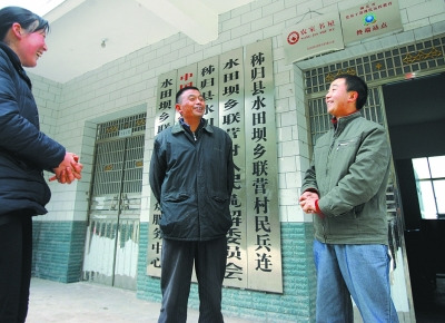 张义波(右)和村主任等村干部商谈工作。