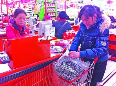 收银台前,收银员正忙碌着为顾客结账。西宁 摄 收银台前,收银员正忙碌着为顾客结账。西宁 摄