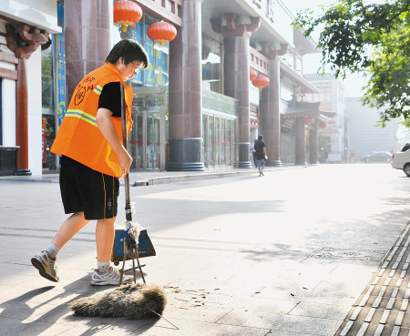 　门晨光同学正在对道路进行保洁。记者刘珂 实习生柴僅悳 周辉珍 摄