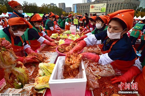资料图：韩国首尔泡菜节举行，民众参与制作泡菜。