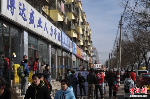 2016年2月19日，在北京市通州区马驹桥商业街上，一些外来务工人员到此寻找工作。吕春荣 摄