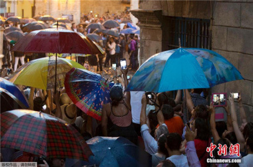 古巴民众冒雨夹道等待奥巴马一行经过。