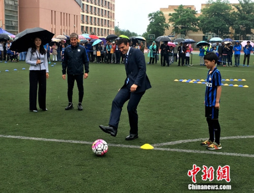 萨内蒂雨中与孩子踢球。中新网记者王牧青摄
