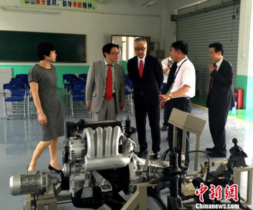 芳贺大辅(左三)和李敏华(左二)在平和县第一职业技术学校参观汽车维修教学设备。　陈悦 摄