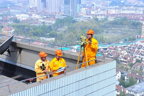 王斌在楼顶进行测量工作。来源：上海建工机施集团供图。