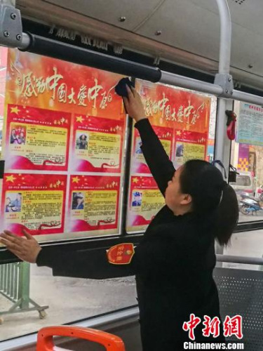 张丽晶一边整理“感动中国大爱中原”海报，一边接受记者采访。　朱航天 摄