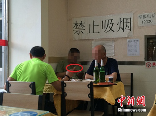 资料图：北京某餐馆，一男子在“禁止吸烟”的标识下抽烟。<a target='_blank' href='http://www.chinanews.com/' >中新网</a> 邱宇 摄