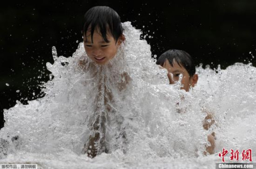 日本东京，儿童喷泉里嬉戏降温