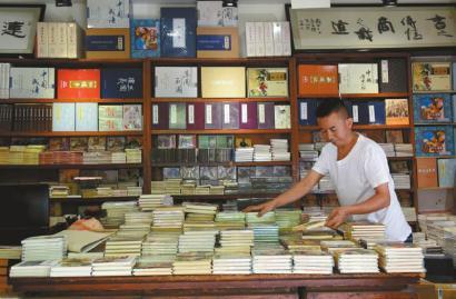 书店老板老刘在整理小人书。