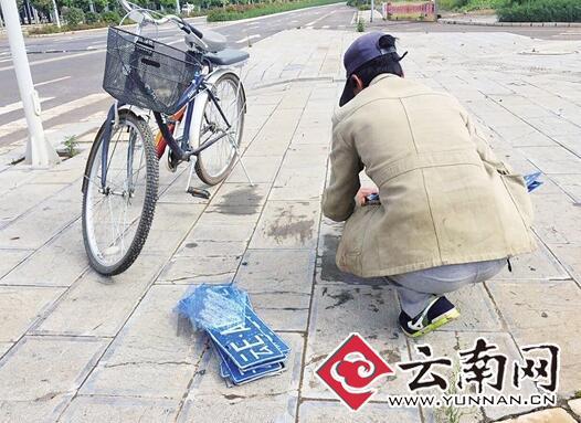 丽江市区路上积水冲掉车牌 有人捡到路边叫卖