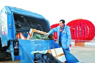 昨天，龙潭春节文化庙会即将结束，李国栋将一堆堆的庙会垃圾装进垃圾车，这个春节的每一天他都是在这样的劳作中度过的。 本报记者和冠欣摄