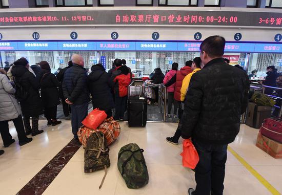 旅客在北京火车站窗口购票、取票。新京报记者 吴宁/摄