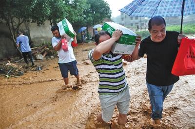 昨日，全州县井门前村，村民用肩扛手提的方式往村中运送生活物资。