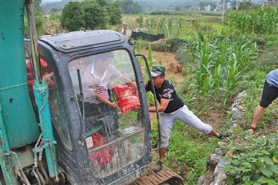 昨日，全州县全福村交通阻断，村民用挖掘机运送生活物资。
