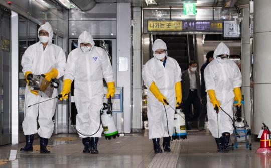 2月28日，在韩国首尔，工作人员在光化门地铁站进行消毒。新华社发（李相浩摄）