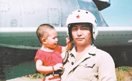 王偉抱著年幼的兒子在戰機前合影。