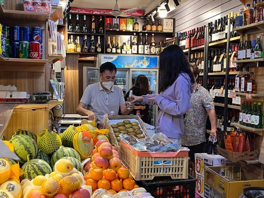 6月1日0点20分左右，上海长乐路上一家烟酒水果店，老板为一位顾客开啤酒。澎湃新闻记者 邹佳雯 图