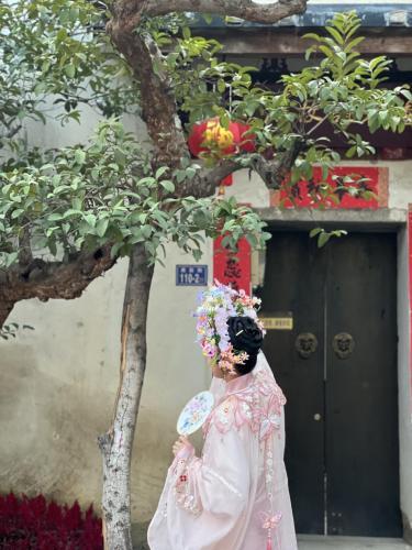 福建泉州，头戴簪花的游客正拍照留念。人民网 欧阳易佳摄