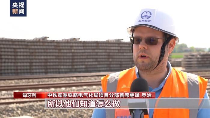 中塞两国工人在巴奇卡托波拉站施工现场共同铺设最后一组钢轨