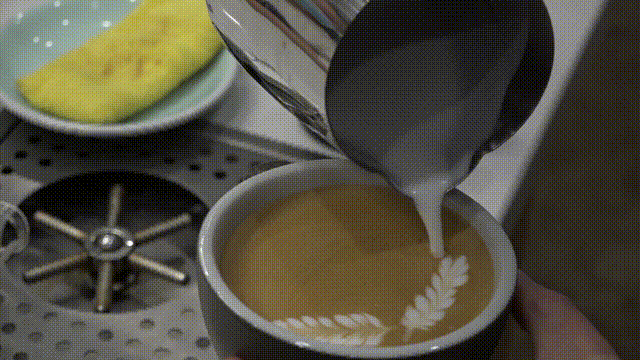 图为重庆90后小伙正在咖啡上制作拉花。