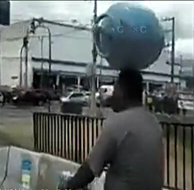 巴西男子头顶煤气罐骑车毫不费劲 自如穿梭(图)