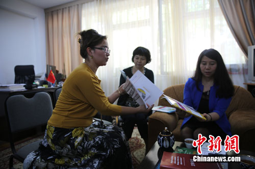 塔什干孔子学院老师向记者展示用乌兹别克斯坦语、俄语编写的汉语教材。