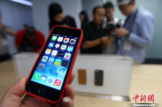 资料图：2013年9月11日，媒体记者在试用iPhone5s及iPhone5c。当日，苹果公司在中国内地的首次新品发布会在北京国贸三期的苹果公司会议室举行。中新社发