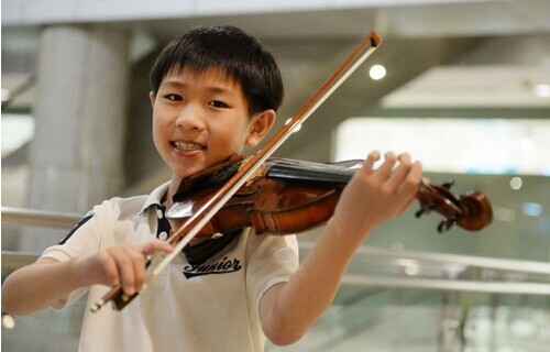 陈奕希年仅9岁，就已展现出对小提琴演奏无比的热情和专注。（马来西亚《光明日报》）