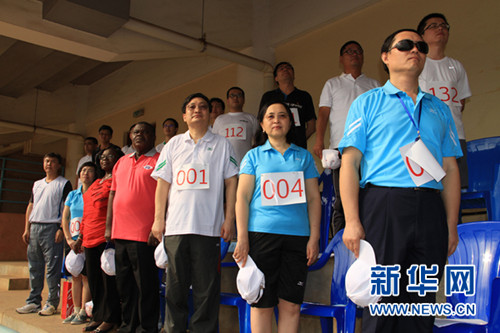 中国侨网中国驻多哥大使刘豫锡（前排右三）、多中友协主席阿博（前排右四）等在运动会开幕式上聆听中多两国国歌。（新华网/张改萍 摄)