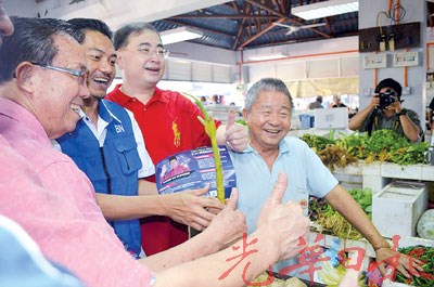 中国侨网华裔菜贩李清吉（72岁）送苏海米一棵蒜，祝愿他“当选”。（马来西亚《光华日报》）
