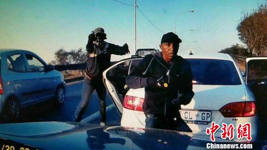 中国侨网在南非，劫匪从车上蹿下后实施抢劫。受害者行车记录仪拍摄视频截图　摄