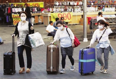 中国侨网七日，外国游客戴着口罩在首尔明洞街头行走（《新民晚报》/图 IC)