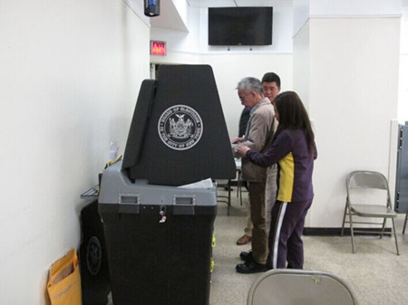 纽约曼哈顿华埠投票站3日普选好冷清，两名工作人员一同协助一名选民投票。(美国《世界日报》资料图