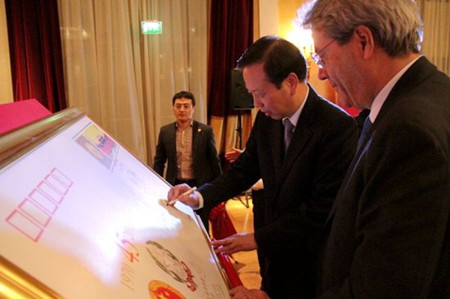 李瑞宇大使与真蒂洛尼外长共同为中意建交45周年纪念封签名。（意大利欧联网）