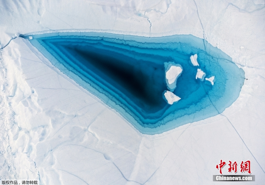 格陵兰岛冰山顶部融洞现绿松石色水域