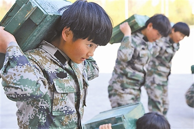 新疆军区新兵连女兵扛弹药箱进行深蹲起立训练