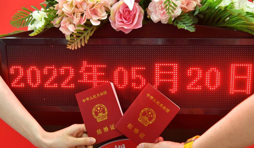 5月20日早6時許，重慶市江北區民政局婚姻登記處前來辦理結婚證的情侶，已排起數十米長龍，現場工作人員正嚴格落實戴口罩、掃碼進場、間隔排隊等防疫舉措。