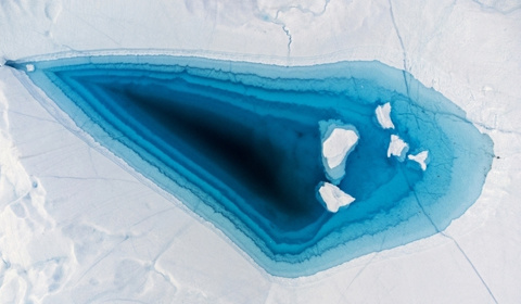 当地时间6月29日，格陵兰岛西部，伊卢利萨特的迪斯科湾，冰山顶部的一个大融洞中出现了绿松石色的水域。