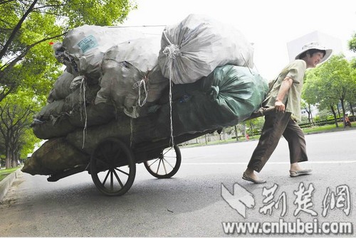 55岁板车妈妈卖废品供儿读大学 拉百公斤走两