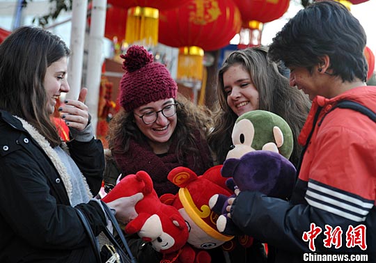 2月3日，留学生各拿一个猴玩偶爱不释手。中新社记者
