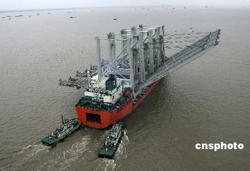 图:特种船装载集装箱吊机安全驶出长江