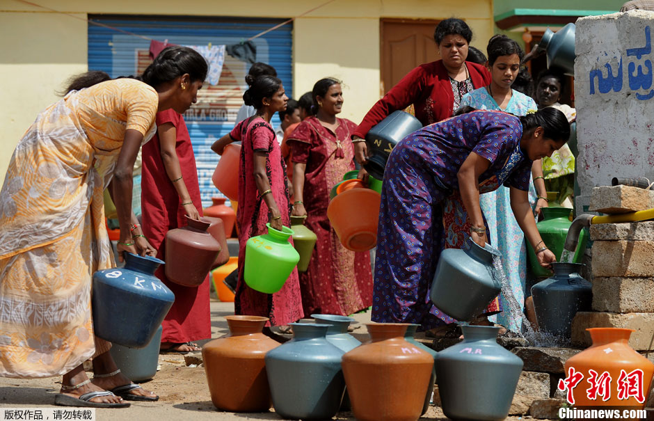 印度饮用水短缺 民众拿彩色水缸排队接水