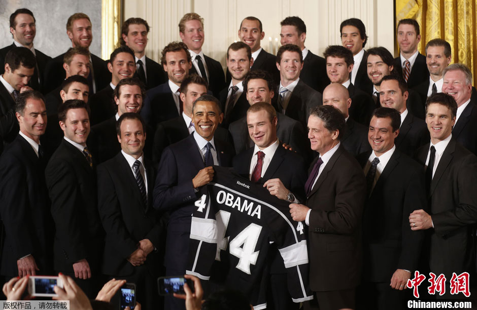 奥巴马接见冰球联盟冠军球队 开心展示获赠球