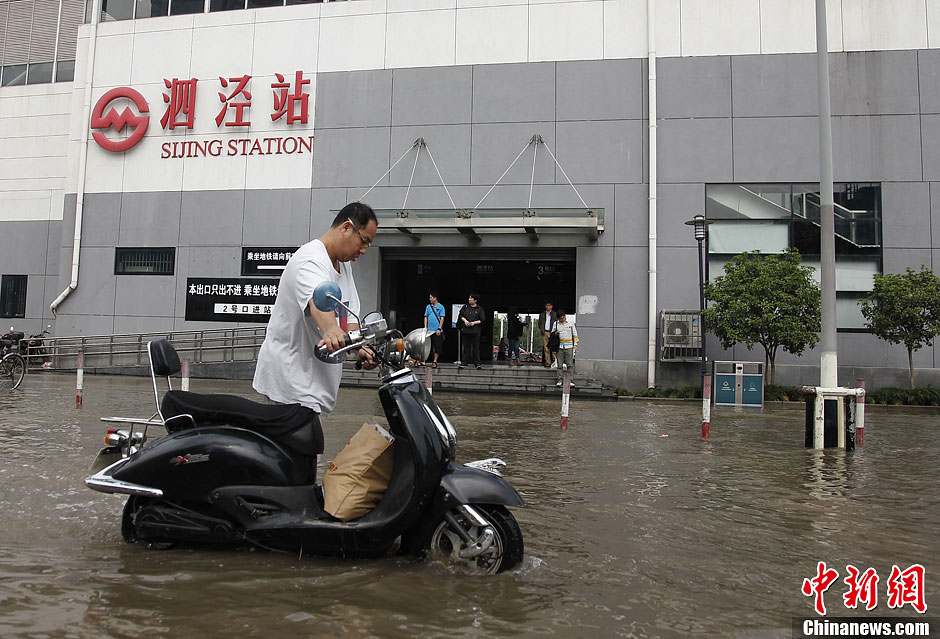 上海暴雨致地铁口积水市民涉水前行