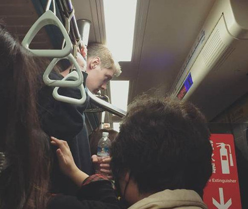 台北地铁上一男子因太高头顶天花板网友喊“好累”