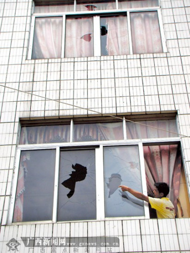 梁某进家的多扇窗户玻璃被砸破.记者 赵敏摄