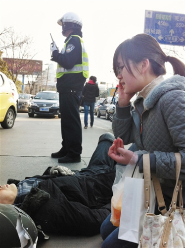 男子遇车祸躺倒街头 过路女孩跪地照料伤者(图)