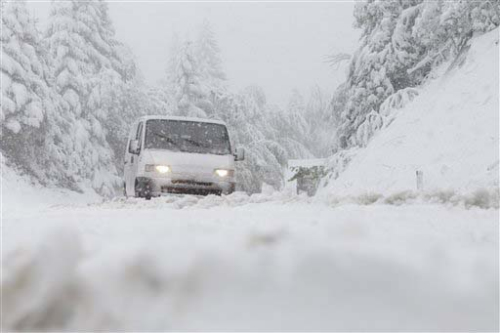 道路被厚厚的积雪覆盖，车辆行驶缓慢